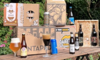 Tafel in de tuin met allerlei bierpakketten, flesjes, en blikjes en glazen met bier 