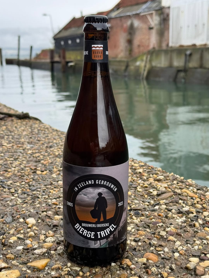 Bierse Tripel bierflesje op de kade aan het water in Yerseke