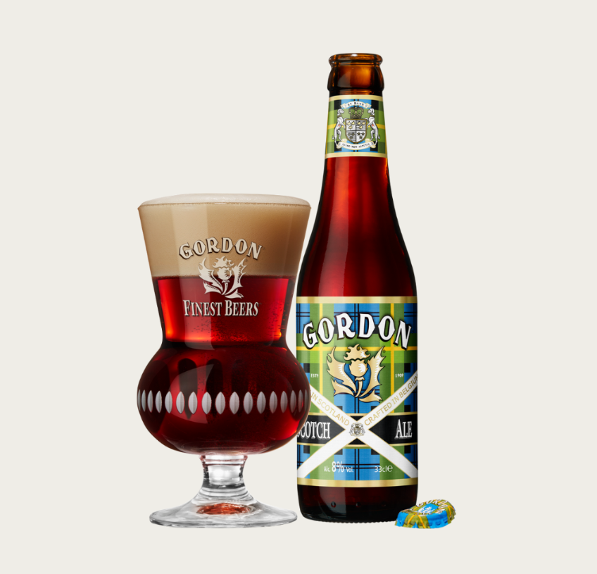 Glas en fles Gordon Finest Beers Scotch Ale met een kroonkurk ernaast.