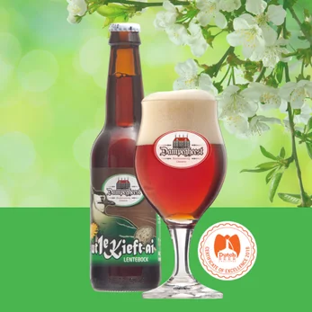 Fles en glas Dampegheest Ut 1e Kieft-ai bier met lentetakken op de achtergrond.