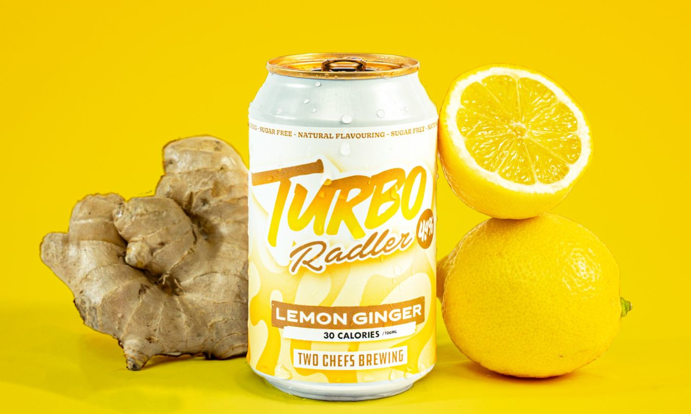 Blikje Turbo Radler Lemon Ginger met citroen en gember op een gele achtergrond.