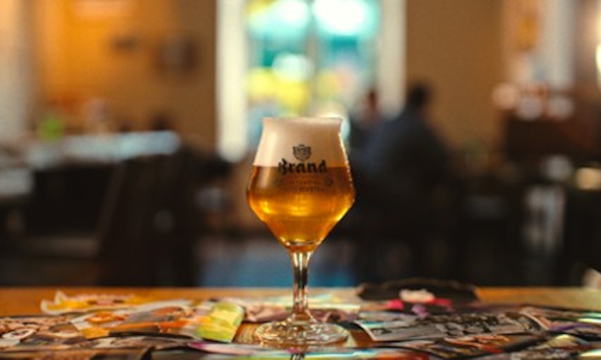 Glas Brand bier op een tafel met wazige achtergrond in café.