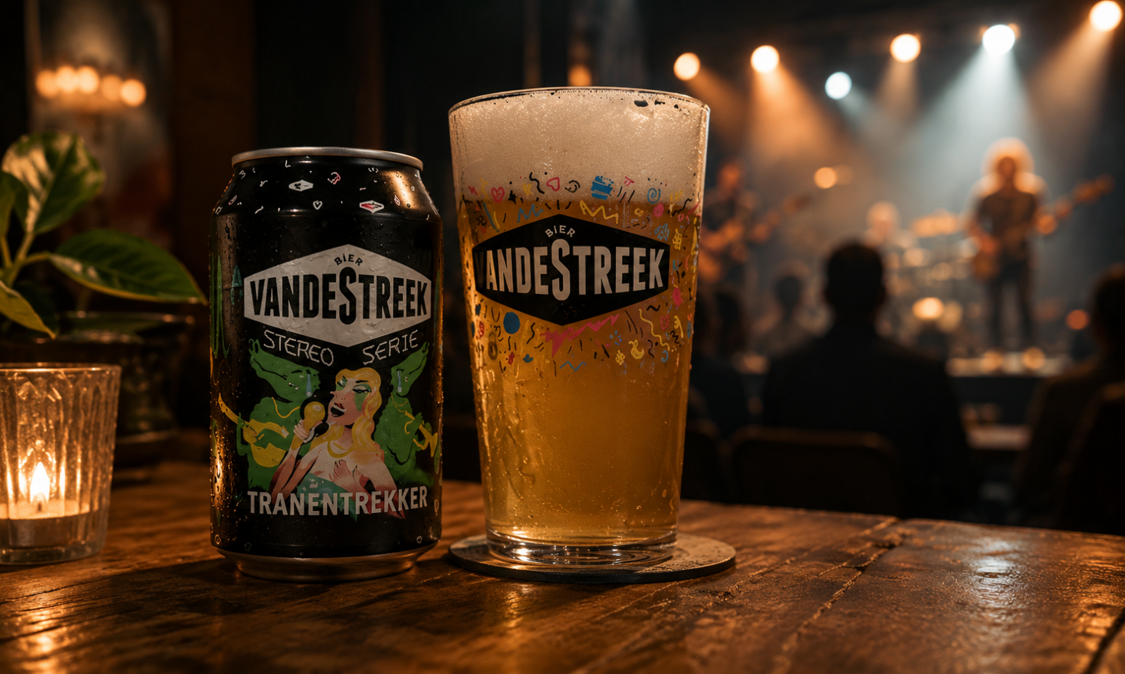 Blik vandeStreek Tranentrekker naast een vol bierglas op een houten tafel, met wazig livepodium op de achtergrond.