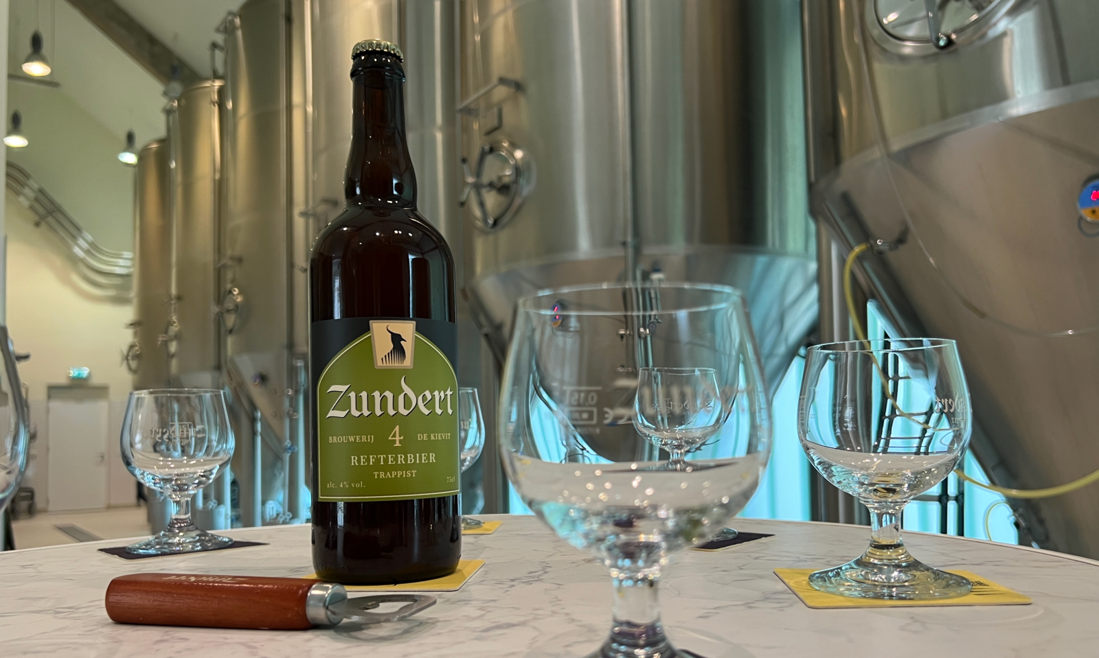 Zundert 4 Refterbier grote 75cl fles naast glazen in de brouwerij Zundert 4 Refterbier grote 75cl fles naast glazen in de brouwerij