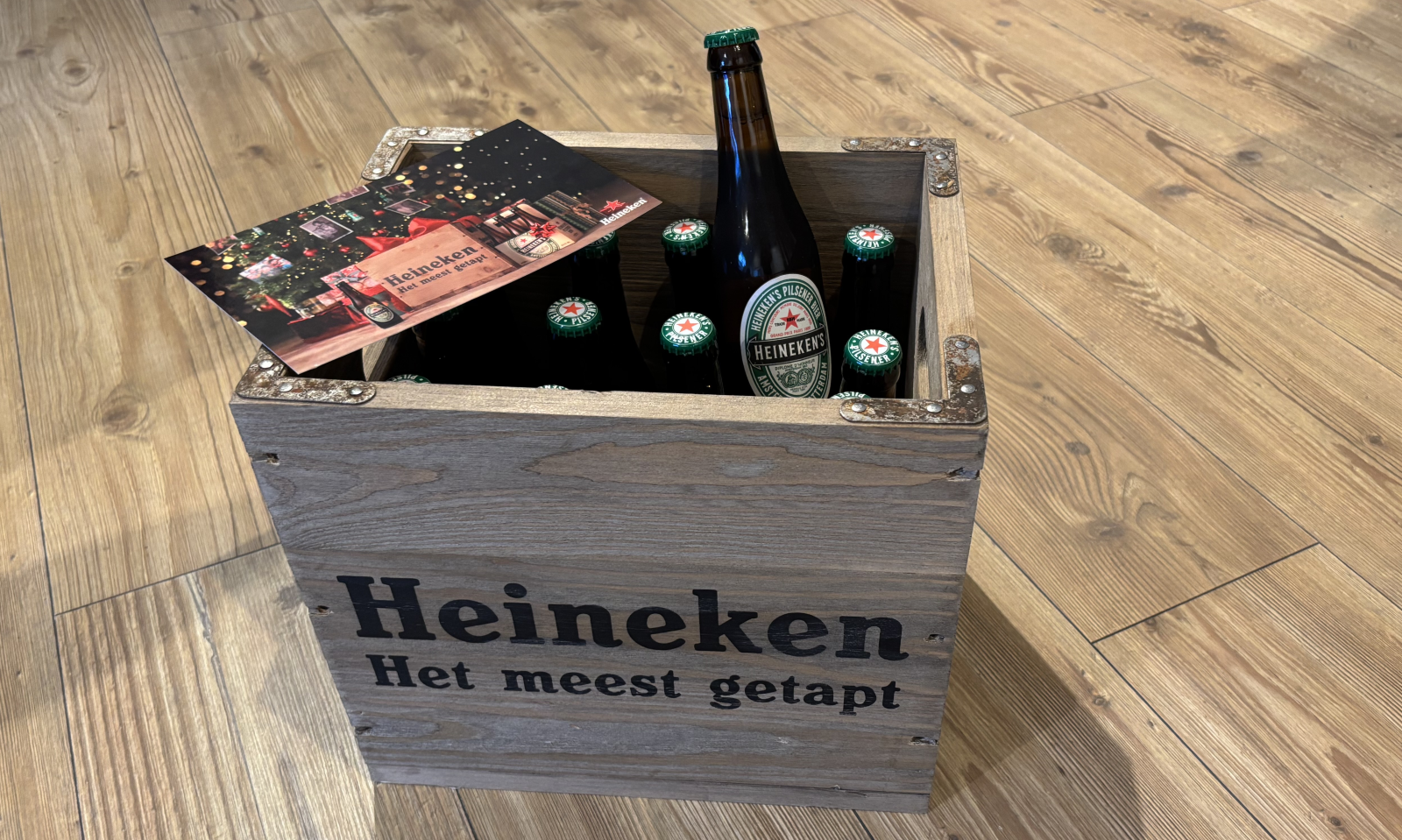 Heineken houten kratje met de tekst 'Heineken Het meest getapt' erop met bruine flesjes Heineken pils erin