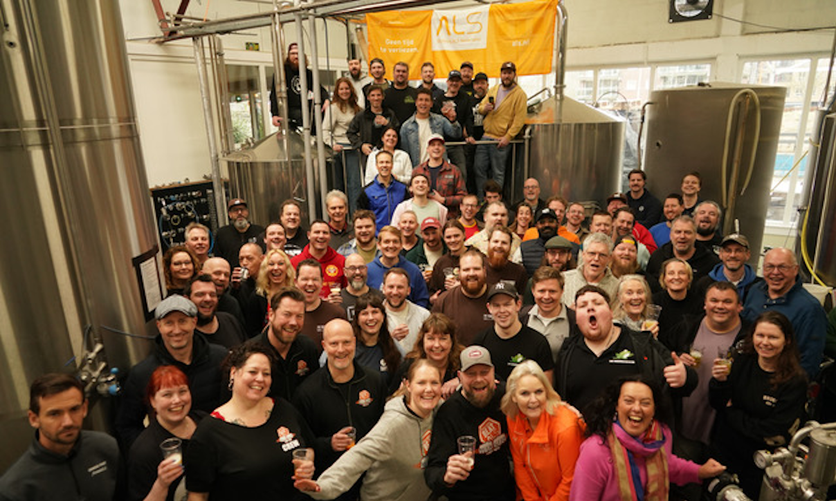 Grote groep mensen verzameld in de Baxbier brouwerij voor een goed doel evenement.