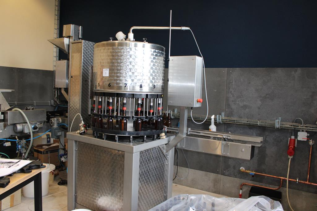 RVS brouwinstallatie met grote ketels en pijpen in een industrieel gebouw.