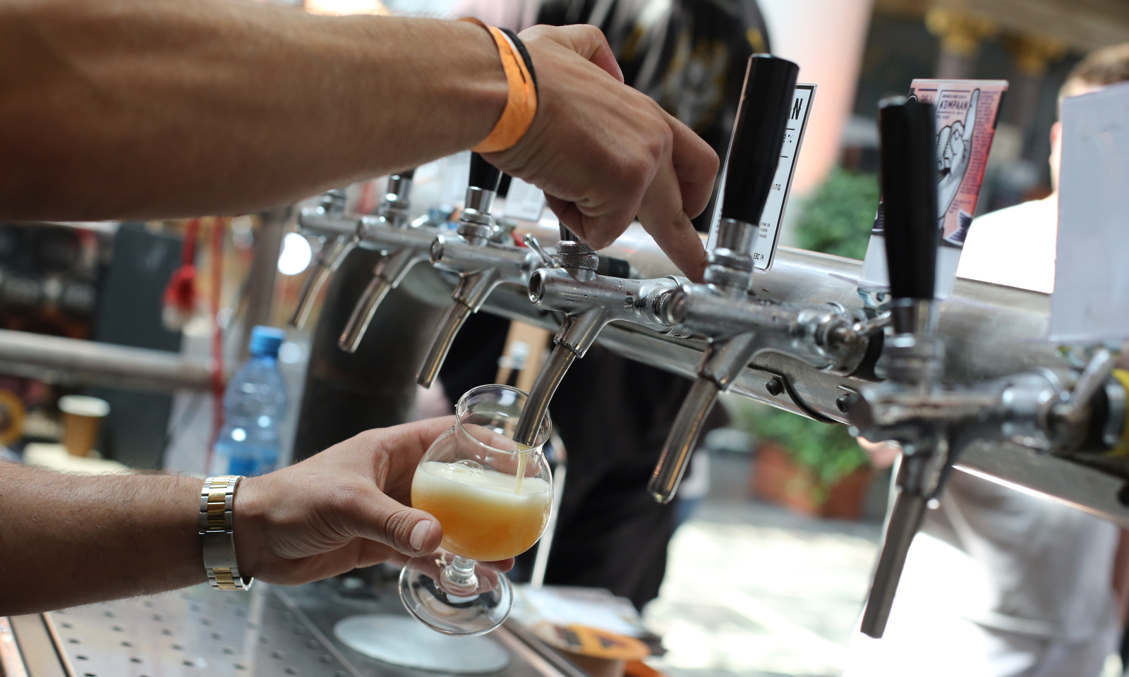 Persoon schenkt bier vanuit een tapkraan in een glas.