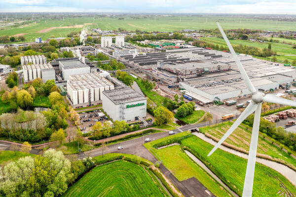 Luchtfoto van Heineken brouwerij met windturbine en groene omgeving.