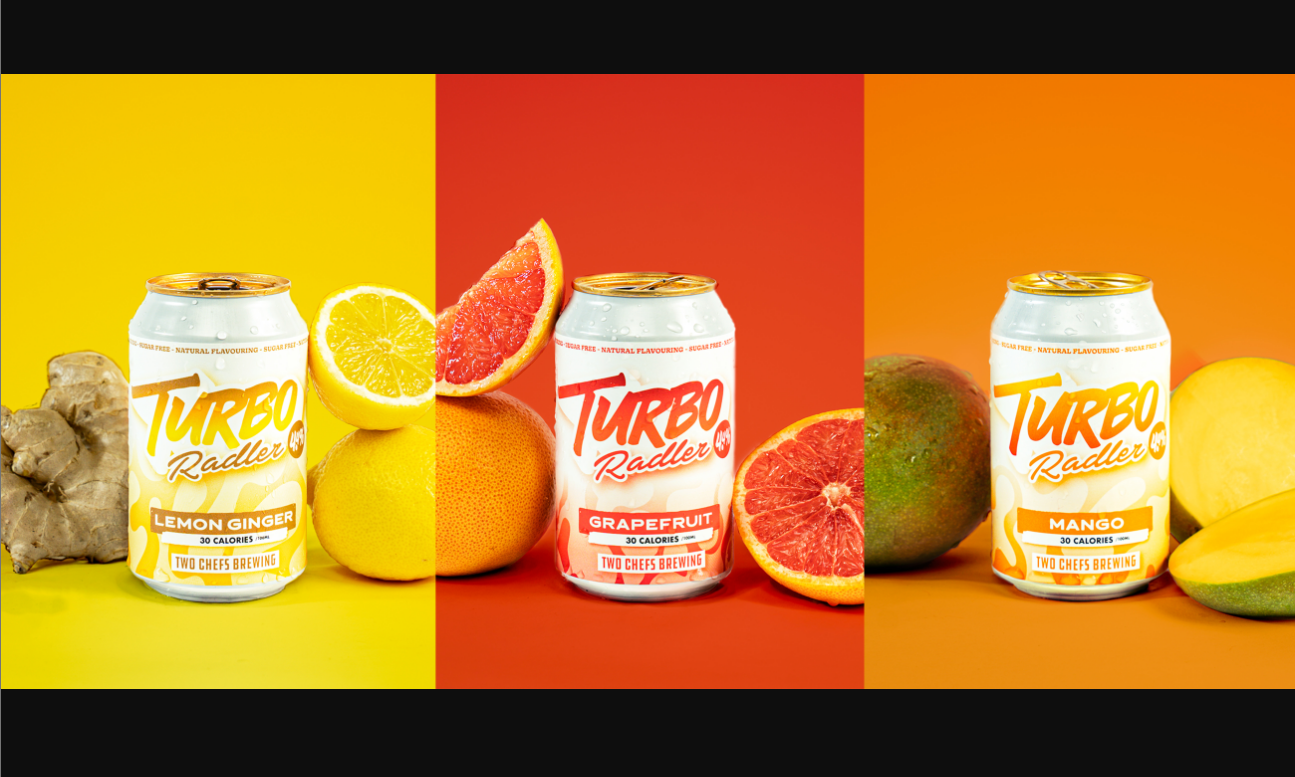 Blikjes Turbo Radler in drie smaken voor kleurrijke achtergronden met bijpassend fruit.