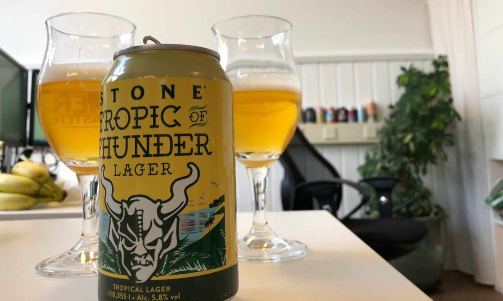 Tropisch Stone Tropic of Thunder blikje en glazen bier op tafel.