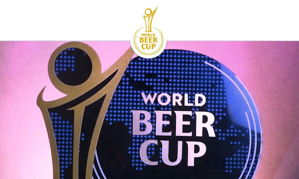 World Beer Cup logo met gouden figuur en blauwe wereldkaart achtergrond.