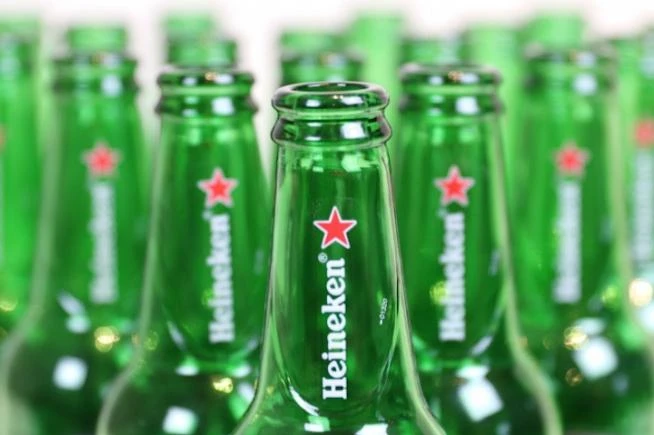 Close-up van meerdere groene Heineken bierflesjes met centraal zicht op het logo.