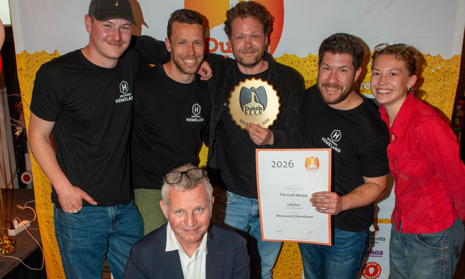 Groep mensen viert prijswinst met trofee en certificaat op Dutch Beer Challenge.