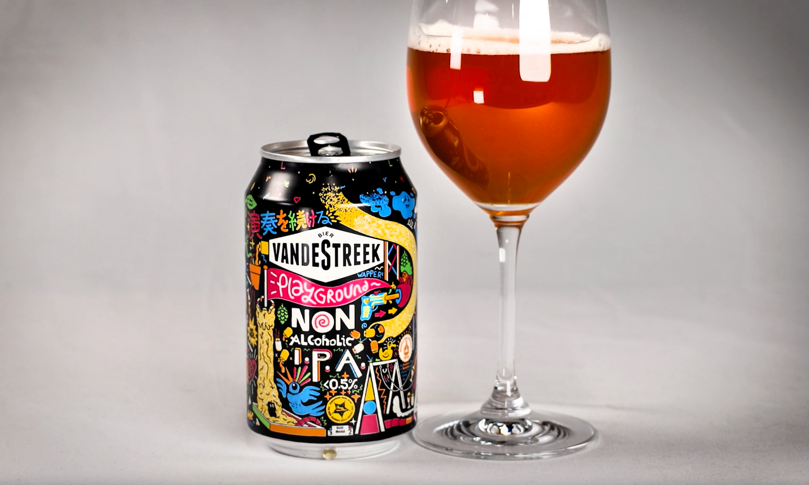 Blikje vandeStreek Playground IPA naast een glas met oranje bier.
