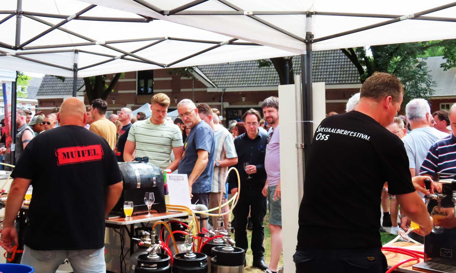 Bezoekers proeven bier bij taps en fusten onder witte tenten op Speciaalbierfestival Oss.