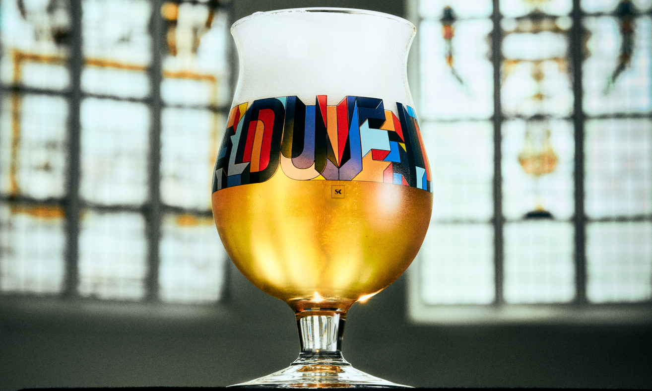 Duvel designerglas met gouden bier, schuimkraag en kleurrijke typografie voor glas-in-loodramen.
