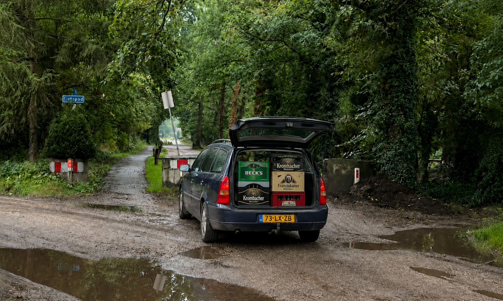 Auto met open kofferbak vol Duitse bierkratten op een modderige bosweg met plassen.