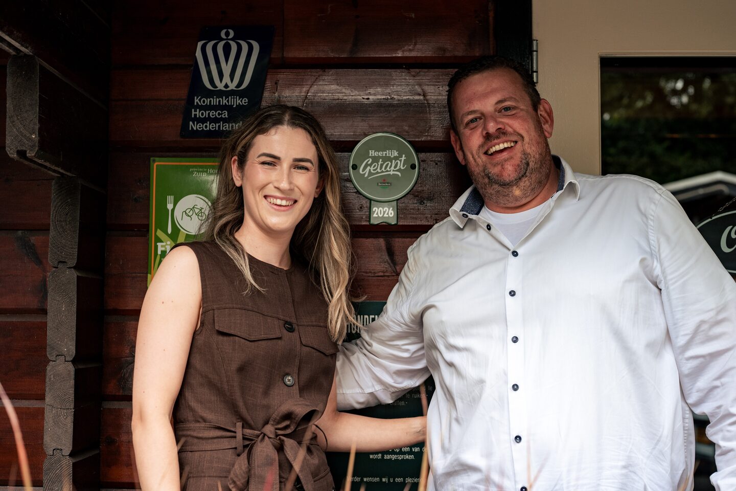 Melanie Zeelenberg van Restaurant 't Zeeltje en Albert Han Wiggers van Heineken bij de gevel met het Heerlijk Getapt-schild.