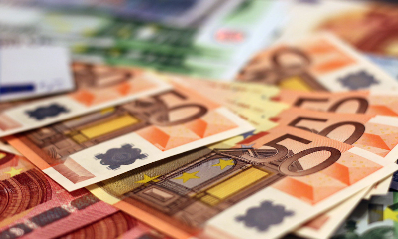 Close-up van verspreide eurobiljetten met meerdere biljetten van vijftig euro in beeld.