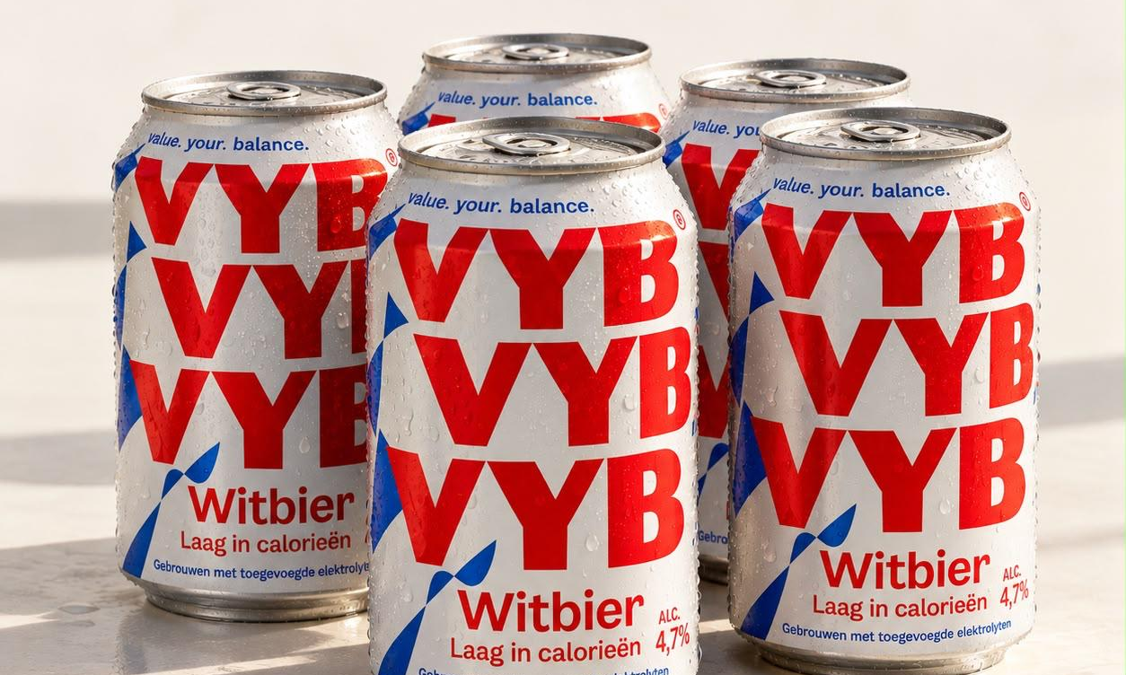 Vijf blikjes VYB witbier met rode en blauwe opdruk op een lichte ondergrond