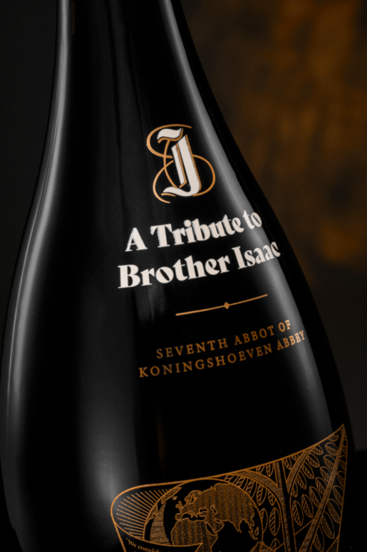 Close-up van een donker magnumfleslabel met witte tekst ter ere van Brother Isaac