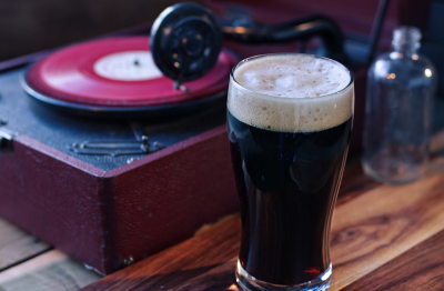 Glas donker bier met een gramafoonplaat voor muziek