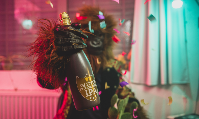 Dutch Bargain Glitter Extravaganza fles vastgehouden door man in apenpak