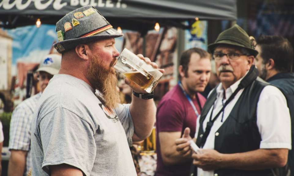 Man in Duitse kleding drinkt bier