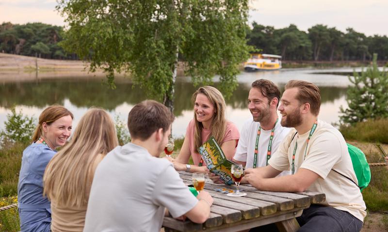 Zes mensen aan een picknicktafel tijdens Brew@theZoo bierfestival