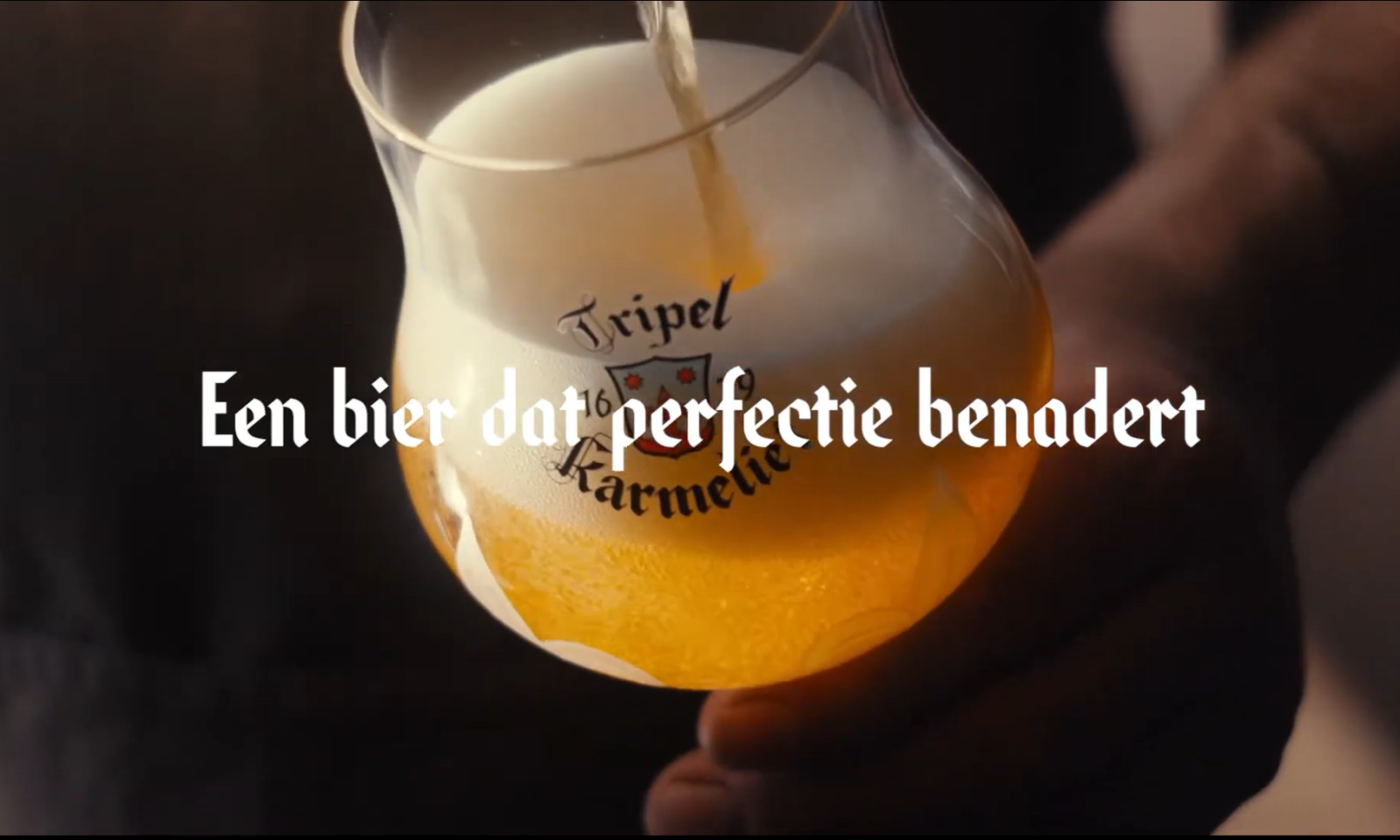 Glas Tripel Karmeliet bier wordt ingeschonken met schuimkraag.