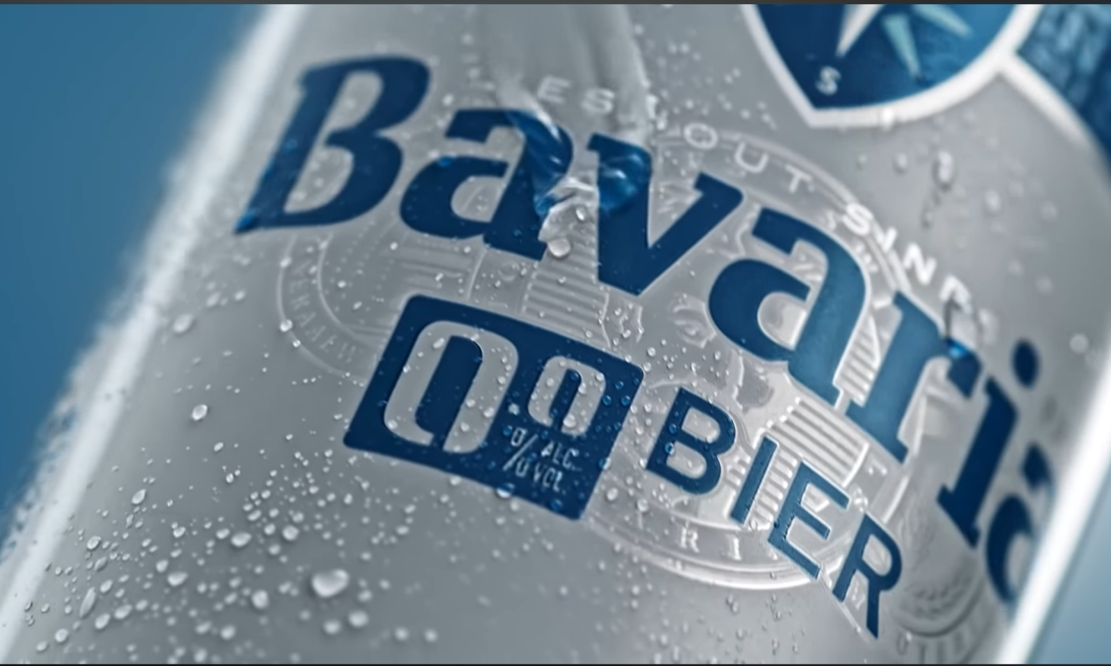 Flesje Bavaria 0.0% bier bedekt met druppels op een blauwe achtergrond.