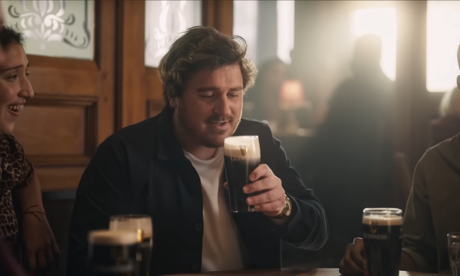 Mensen drinkend in een gezellige pub bij zacht licht.