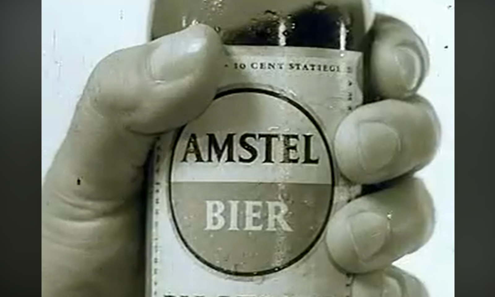 Hand houdt een Amstel bierflesje vast met zichtbaar etiket.