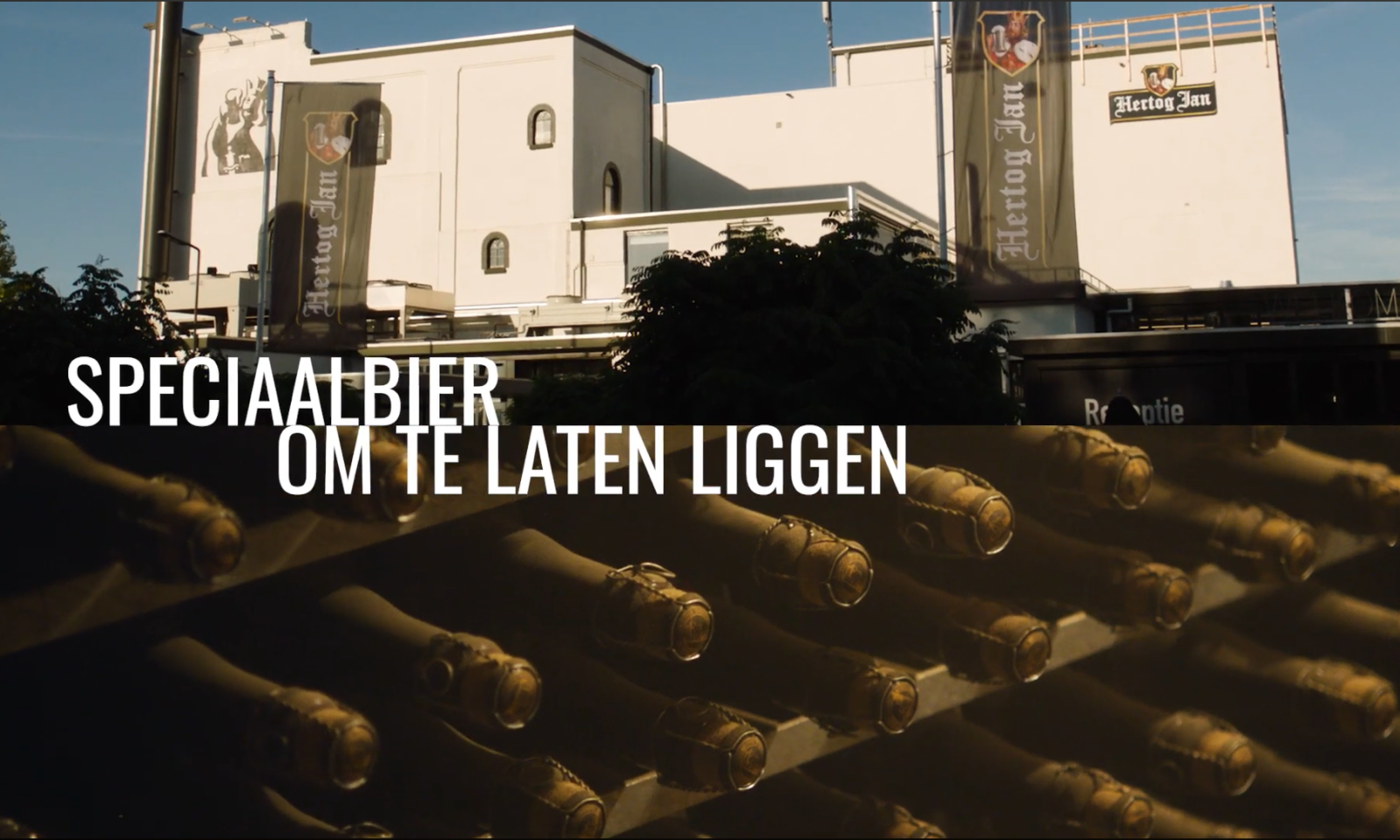 Bierbrouwerij van Hertog Jan met daaronder een rek met flessen Grand Prestige.