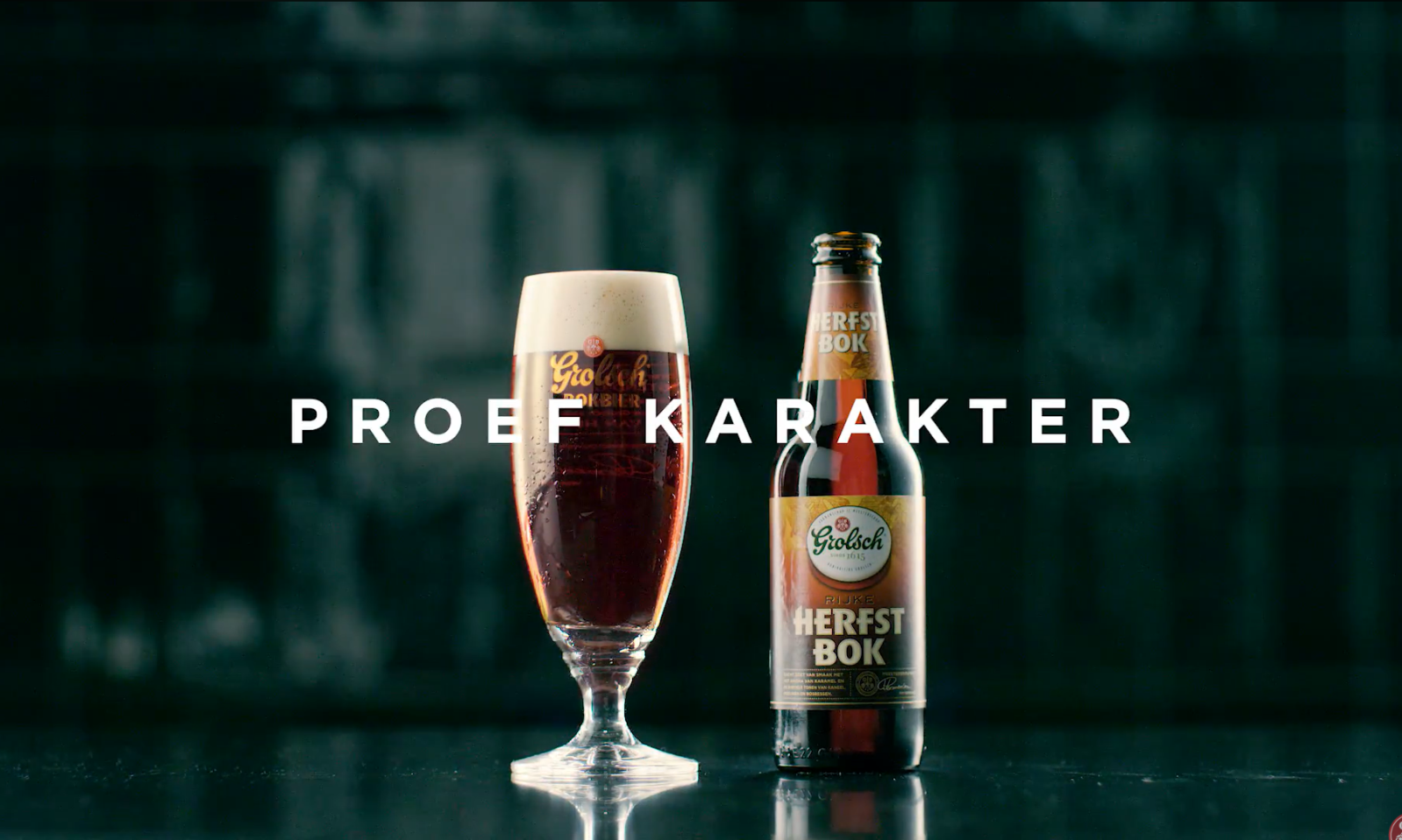 Glas en fles van Grolsch Rijke Herfstbok op een donkere achtergrond.