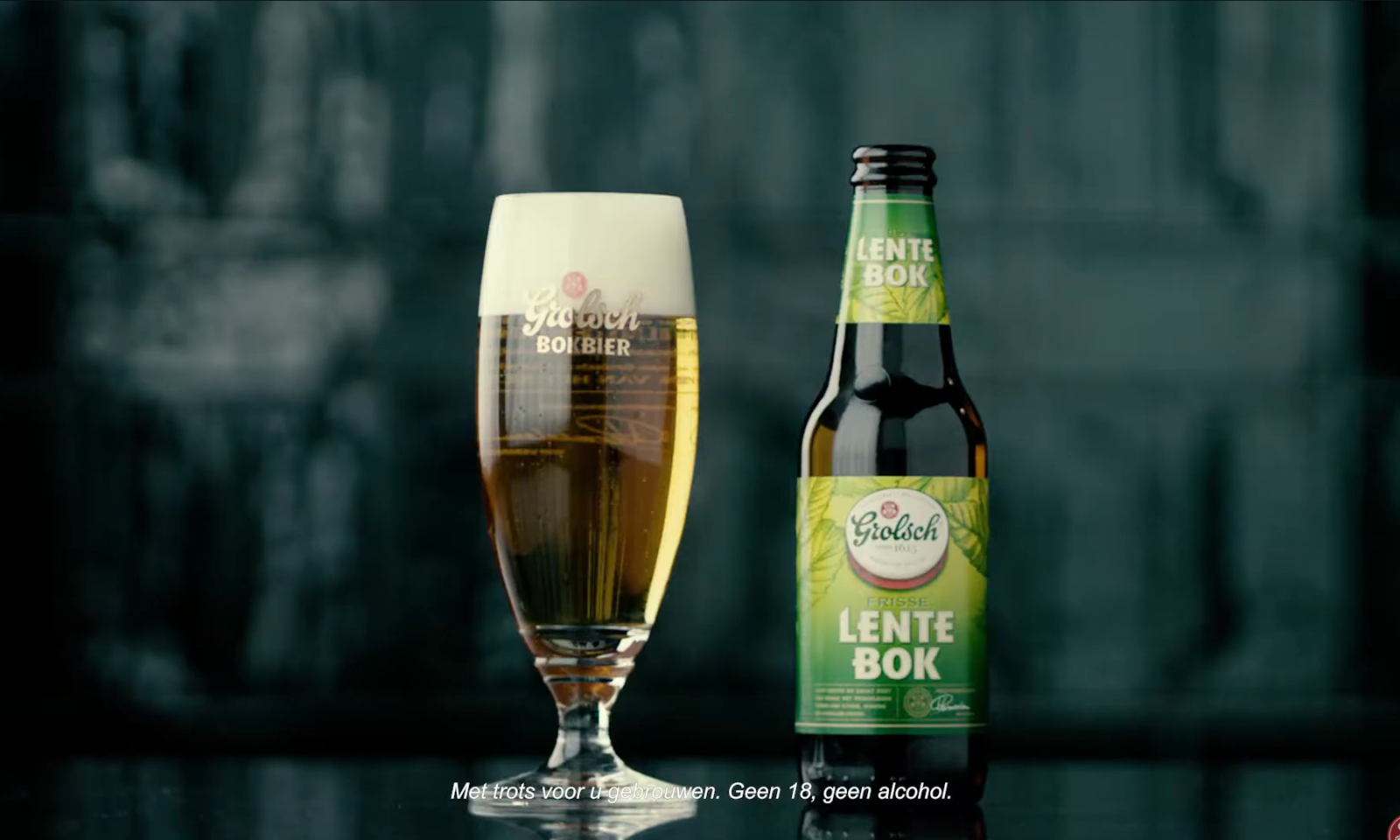 Grolsch Lentebok bierglas en flesje op een donkere achtergrond.