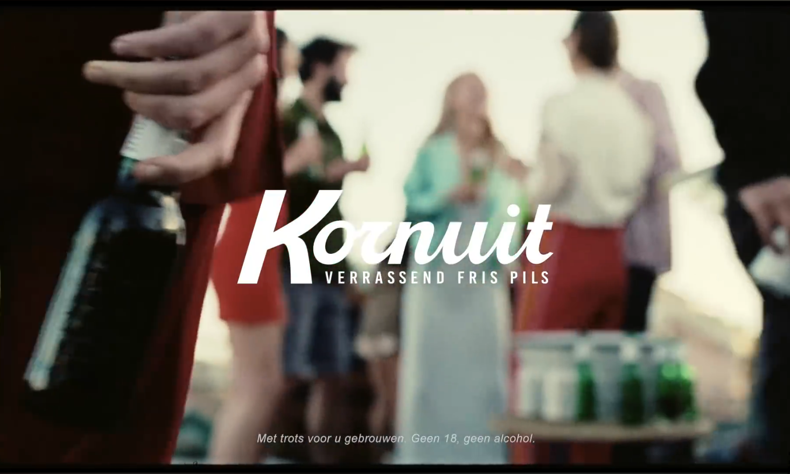 Groep mensen buiten met Kornuit bier in de hand.