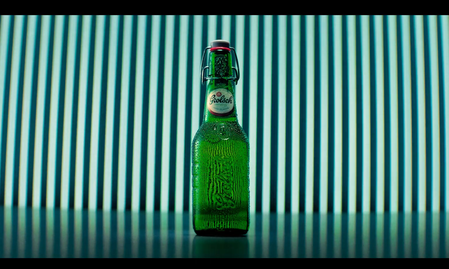 Groene Grolsch bierfles voor gestreepte achtergrond