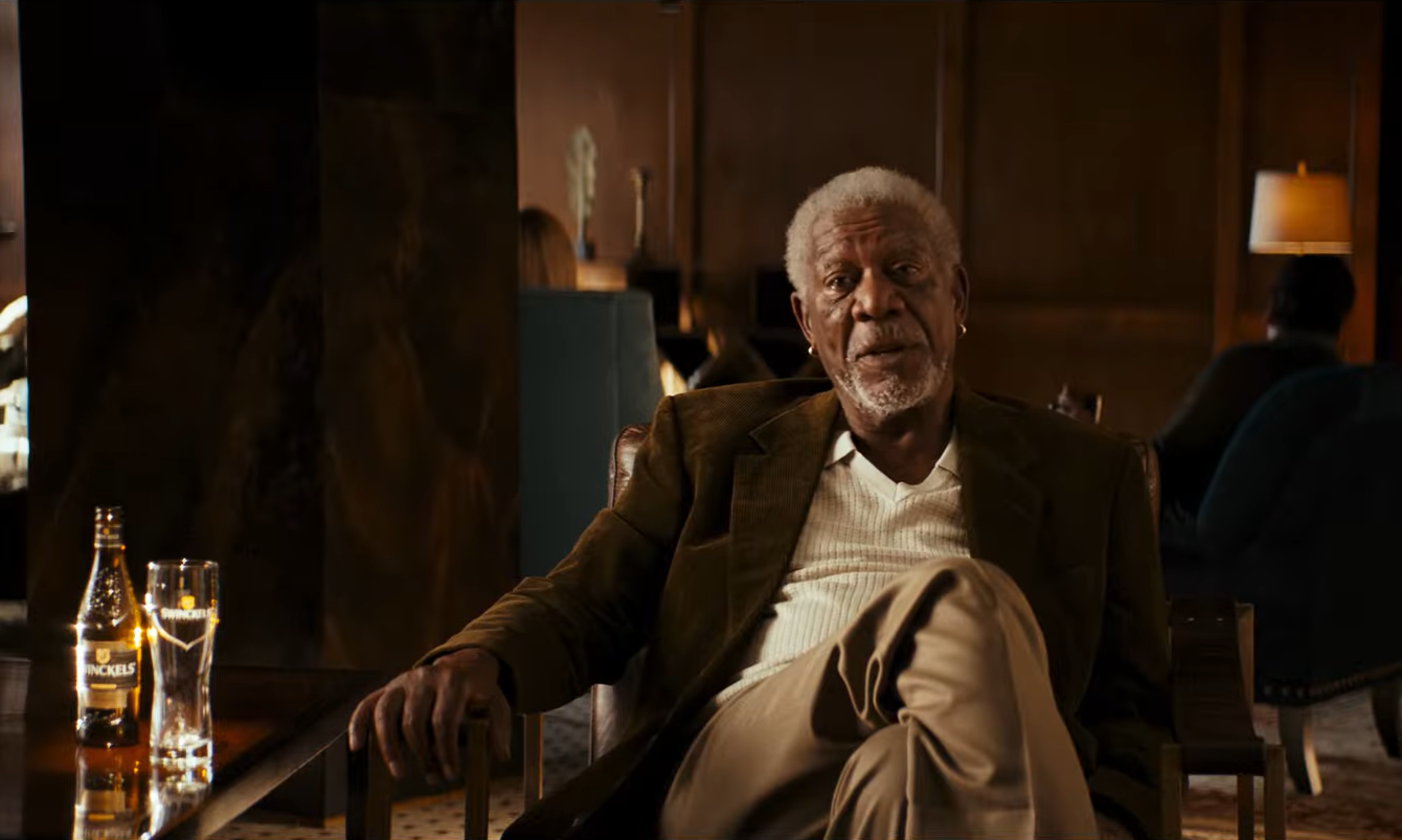 Man zittend in een chique hotel lounge met een fles en glas op tafel.