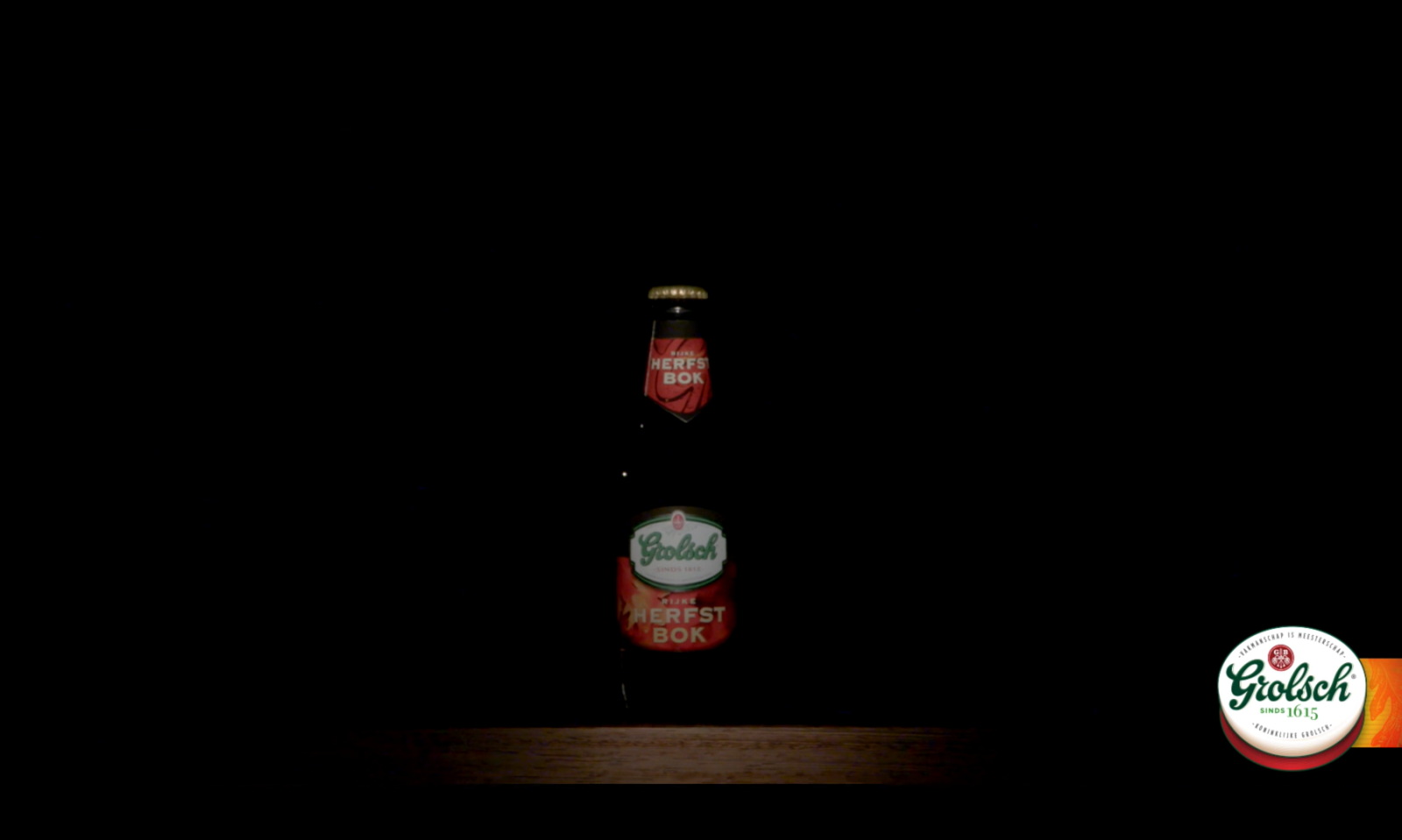 Fles Grolsch Herfstbok op een houten oppervlak met donkere achtergrond.