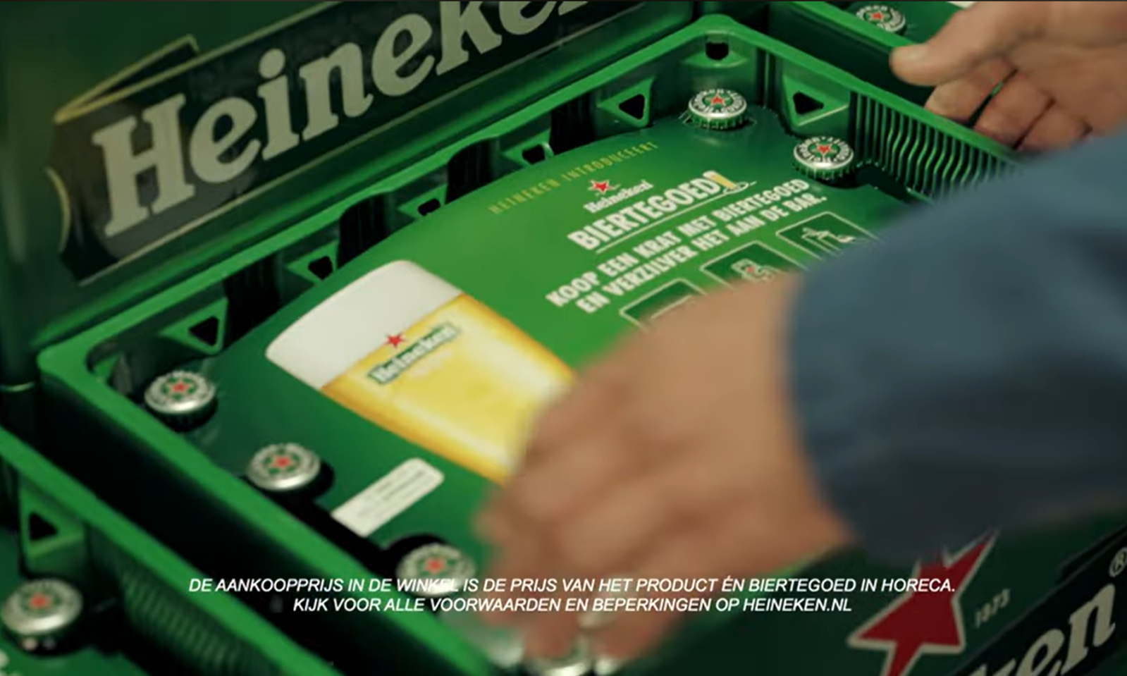 Close-up van een Heineken krat met promotionele biertegoed informatie.