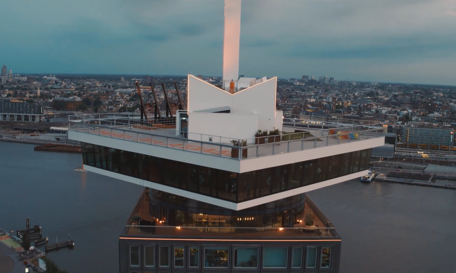 Een modern gebouw met een uitkijkplatform boven de stad en het water.