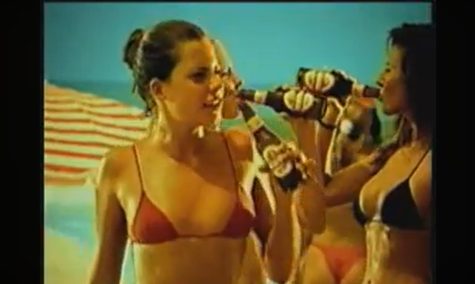 Vrouwen in badkleding drinken bier op een zonnig strand.