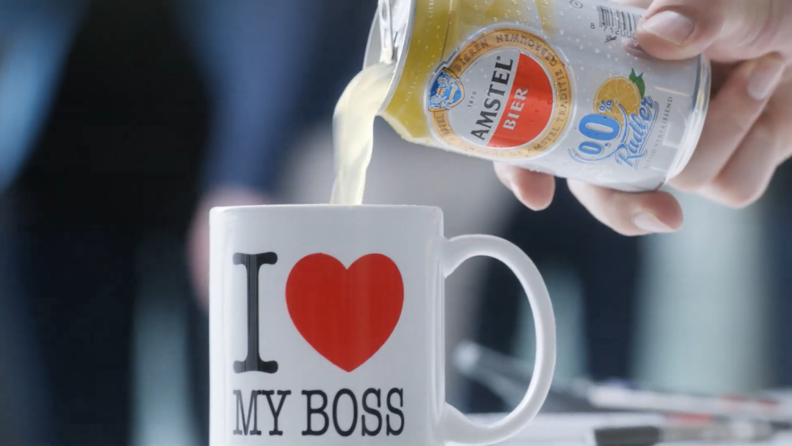 Een Amstel Radler 0.0% blikje schenkt drank in een mok met tekst 