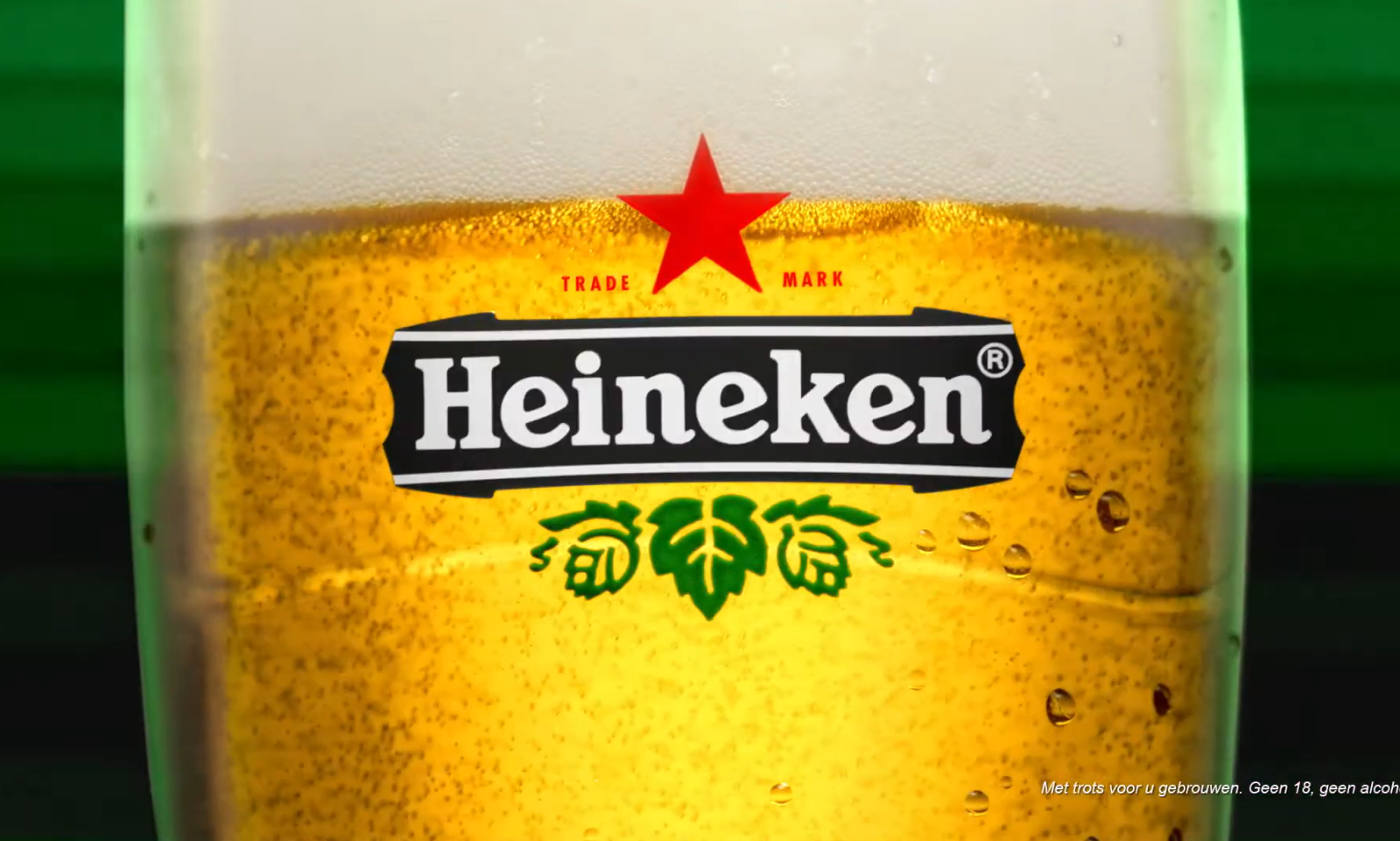 Close-up van een glas Heineken bier met schuimkraag en merknaam zichtbaar