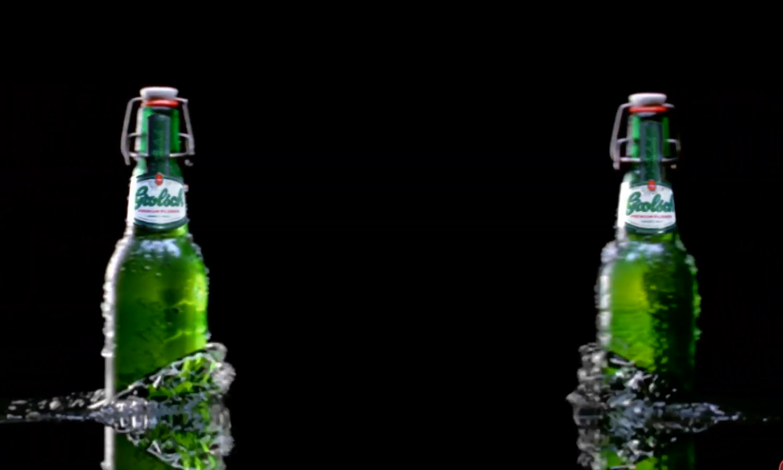 Twee groene Grolsch bierflessen tegen een zwarte achtergrond met spattend water.