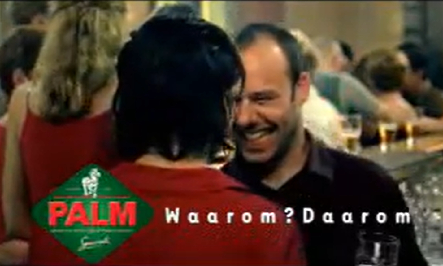 Mensen in een bar met een Palm logo en tekst 'Waarom? Daarom'.