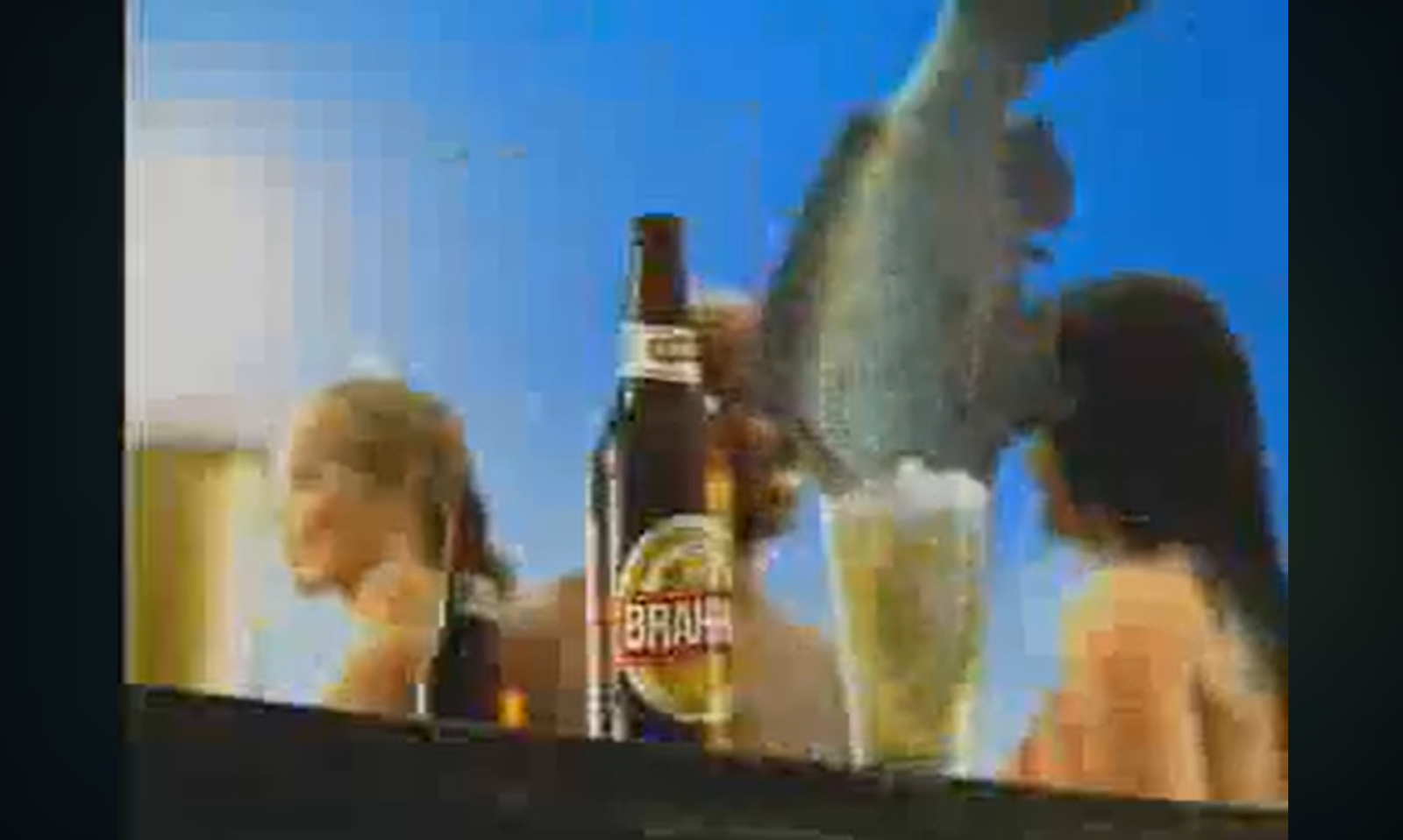 Een fles Brahma bier op tafel met mensen en een vis op de achtergrond.