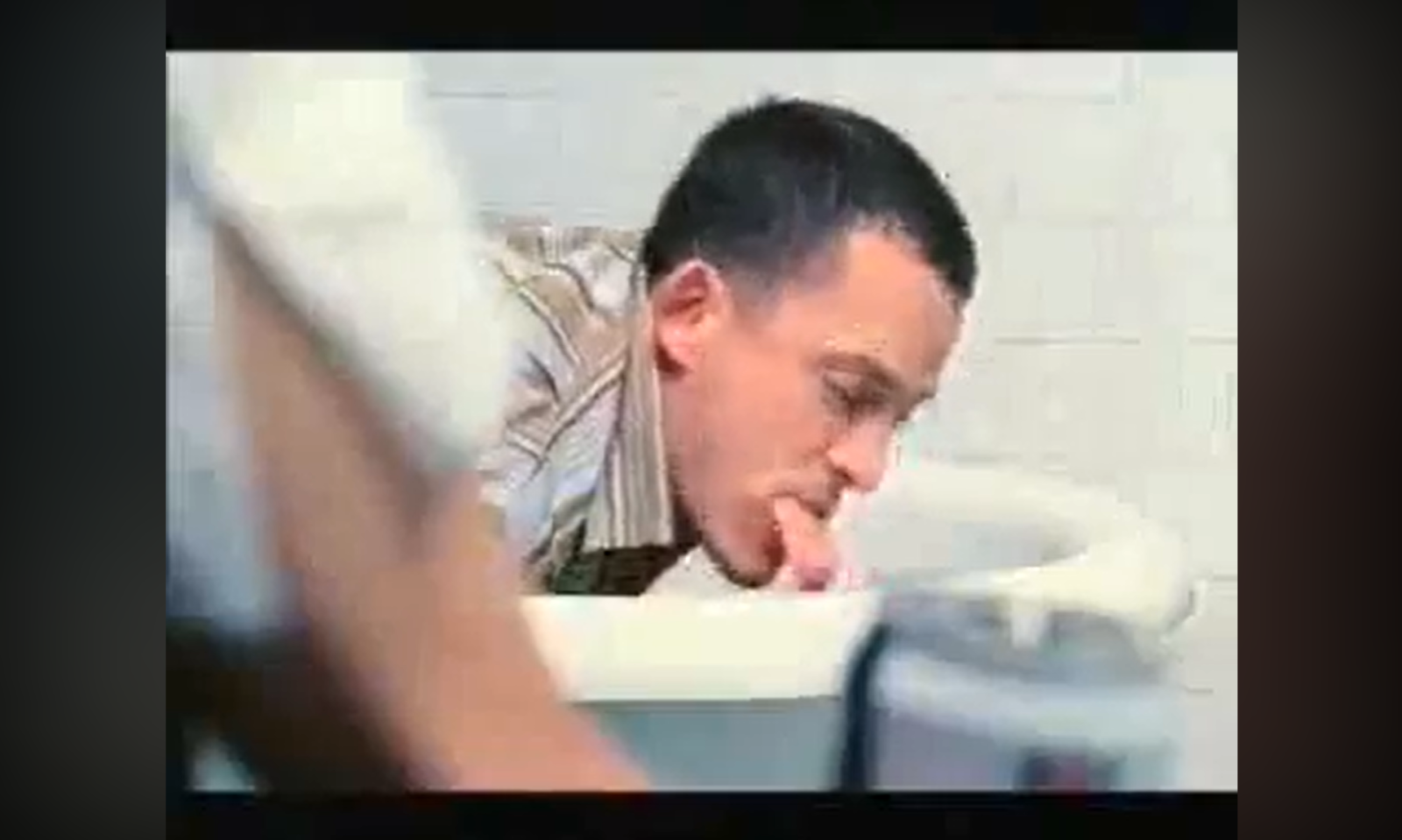 Man bij een wasbak die zich zichtbaar ongemakkelijk voelt.